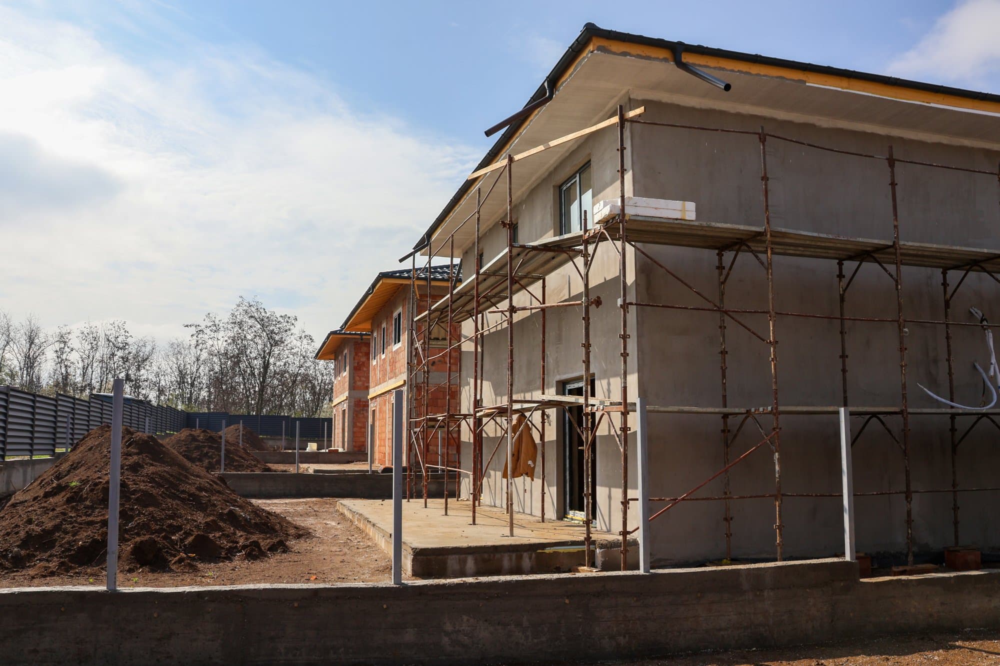 Două case în construcție cu schele